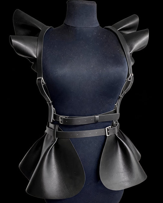 Obsidian Sovereign black faux-leather ruffle harness with peplum, on a mannequin, black background